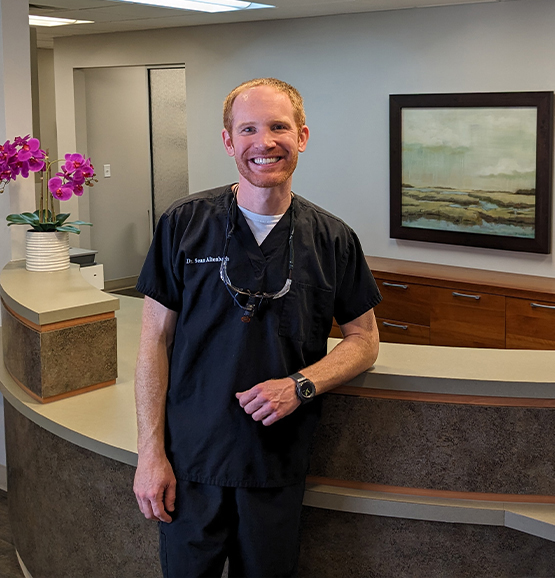 Jacksonville Florida dentist Doctor Sean Altenbach smiling by dental office front desk
