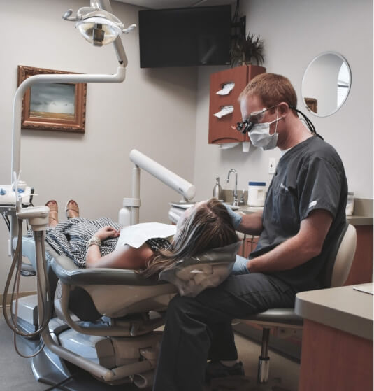 Doctor Altenbach wearing dental goggles as he performs a dental exam on a patient