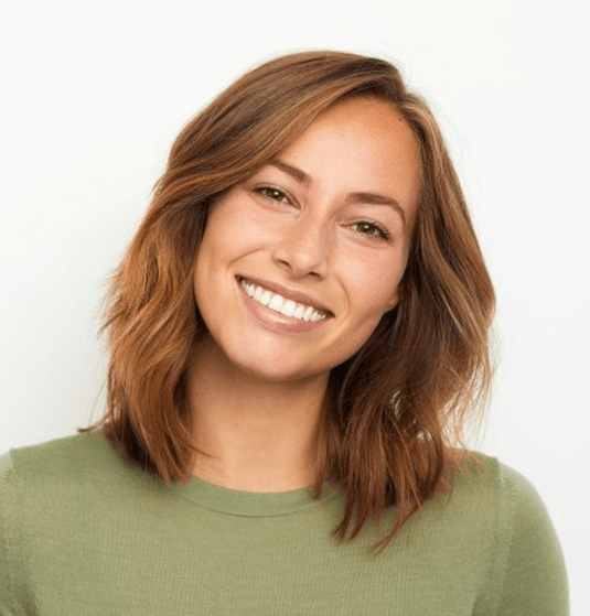 a woman smiling after wearing clear aligners