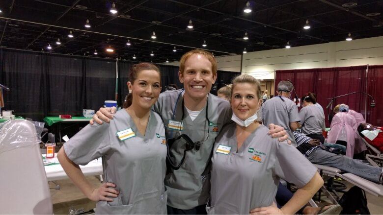 Doctor Altenbach and two dental team members wearing matching gray scrubs