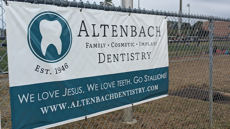 Poster for Altenbach Dentistry on fence at local kids sport complex