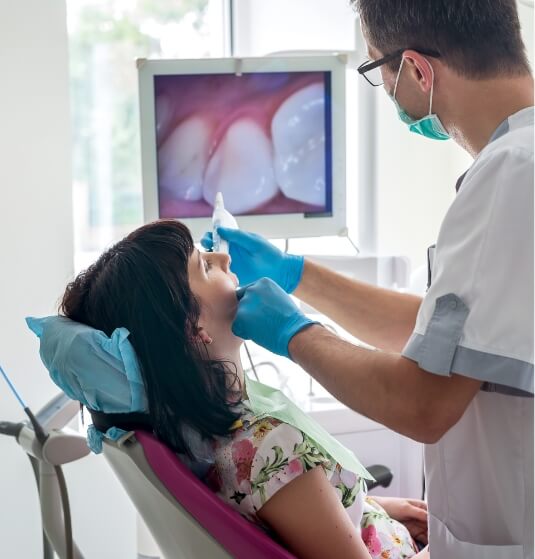 Dentist showing a patient close up images of their mouth using intraoral camera