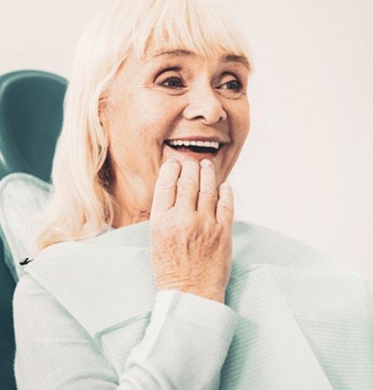 Woman happily looking at her dentures