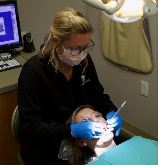 Dental team member examining a patient's mouth