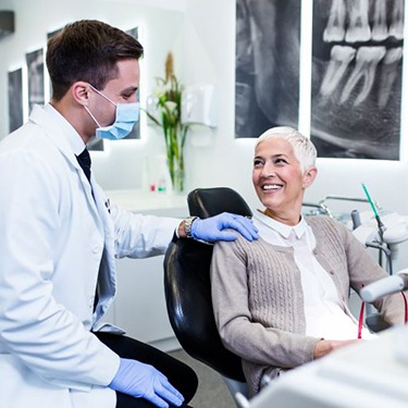 Dentist and dental patient having happy conversation