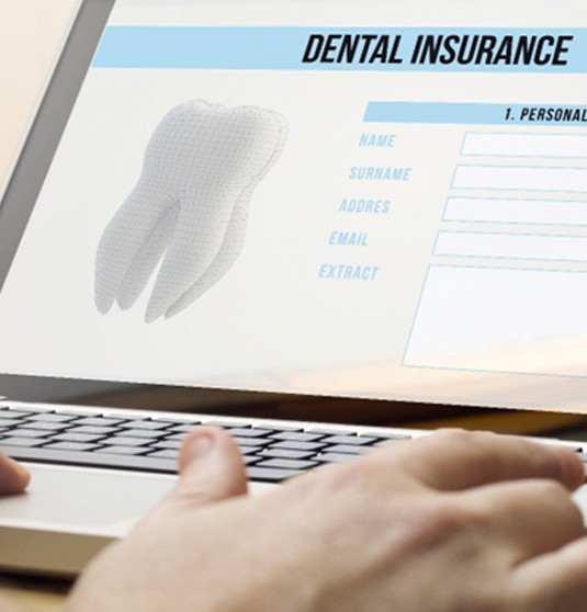 Filling out a dental insurance form on a laptop