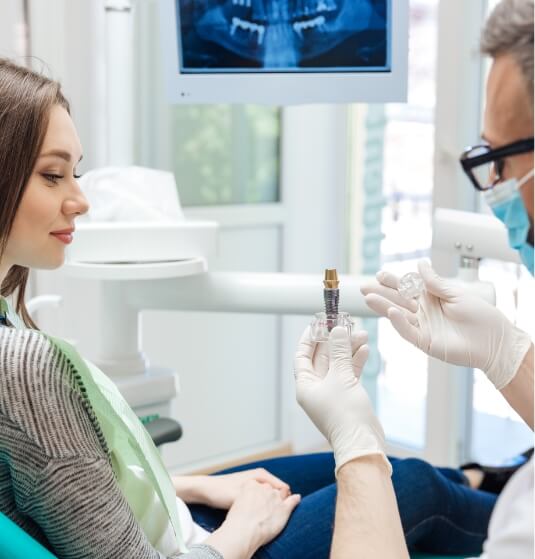 Dentist showing a dental implant to a patient