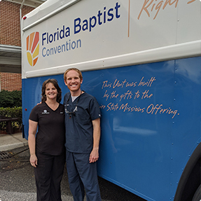 Doctor Altenbach with woman next to bus for Florida Baptist Convention