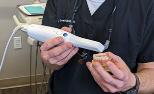 Jacksonville dentist taking a digital scan of a denture to demonstrate for a patient