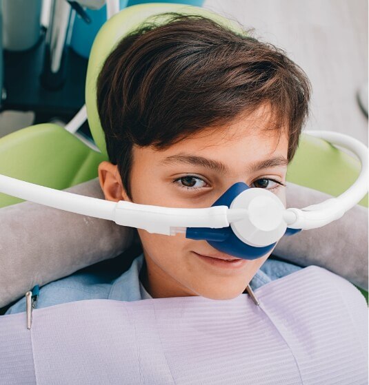 Young boy in dental chair wearing nitrous oxide sedation mask