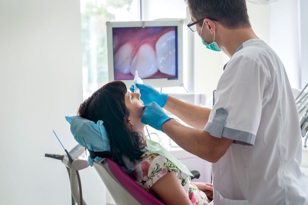 A dentist using an intraoral camera on a patient. 